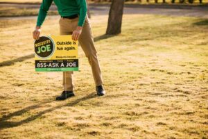 Mosquito Joe technician leaving yard sign after treatment.